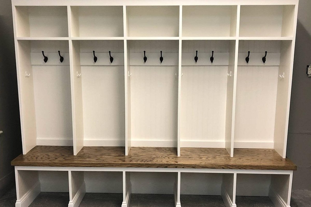 Mudroom lockers with two-height hooks, open cubbies, and a bench